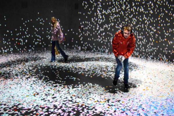 A boy wearing ear defenders and enjoying the interactive gallery at FRAMELESS.