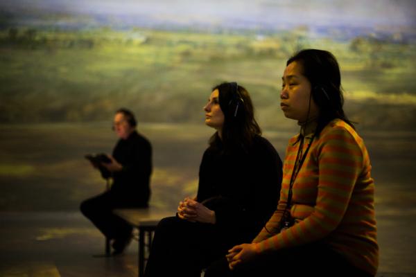 Two woman in the FRAMELESS immersive gallery listening to the audio guide
