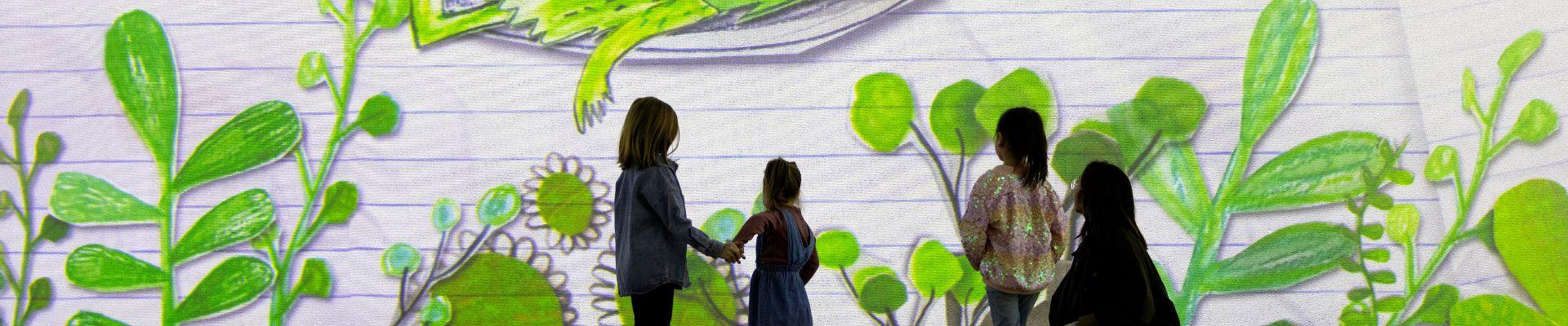 Three children stand with an adult at The Colour Monster at FRAMELESS Immersive Art Experience.