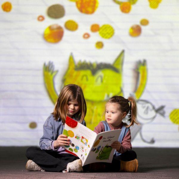 Two children sit in front of The Colour Monster at FRAMELESS immersive art experience.