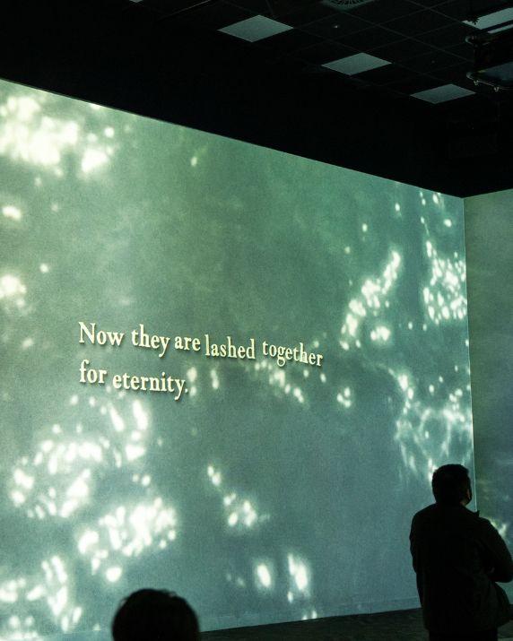 A projected screen showing a coffin with words on the screen.