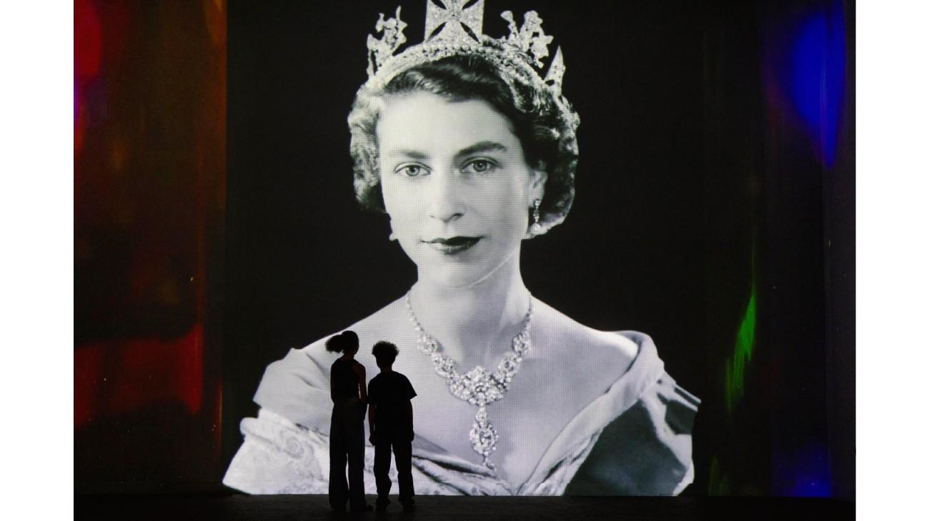 The silhouette of two children in front of a portrait of the Queen from Stories Brought to Life