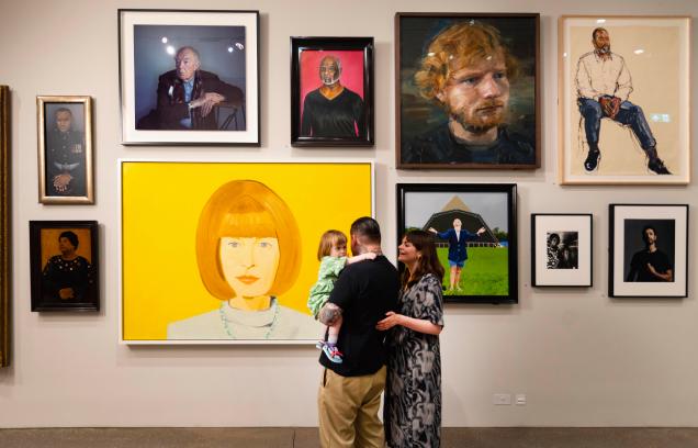 A family standing in front of a gallery wall in the National Portrait Gallery