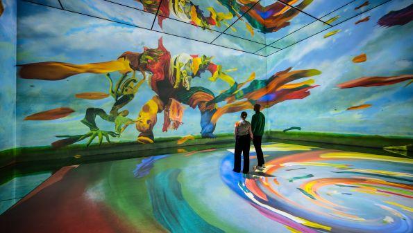Two people inside FRAMELESS immersive art experience.
